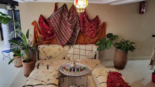 Riad Soir De Marrakech في مراكش: غرفة معيشة مع أريكة مع الوسائد والنباتات