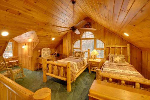 a bedroom with two beds in a log cabin at Riverfront Luther Cottage with Year-Round Trail! in Luther
