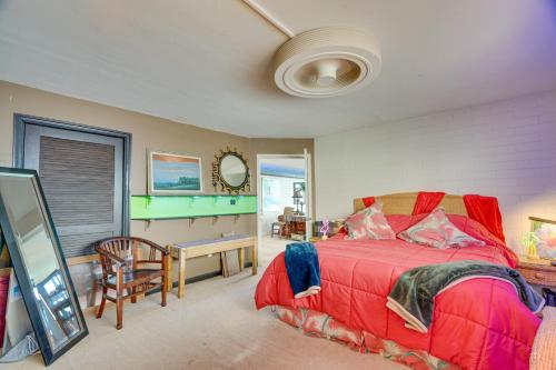 Schlafzimmer mit einem roten Bett und einem Spiegel in der Unterkunft Colorful Poipu Condo with Expansive Ocean Views! in Koloa