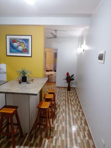 a kitchen with a counter and stools in a room at Hotel Botón de Oro in Puerto Maldonado