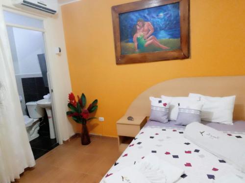 a bedroom with a bed and a painting on the wall at Hotel Botón de Oro in Puerto Maldonado