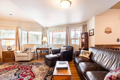 a living room with a leather couch and a table at Meandering Moose Apartment in Black Hawk