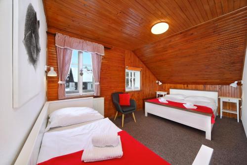 Un dormitorio con 2 camas y una silla. en Chalupa EDEN Harrachov en Harrachov