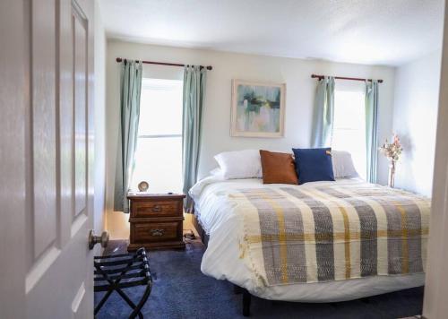 1 dormitorio con 1 cama y 2 ventanas en The Dutch House Family Hideaway, en Klamath Falls