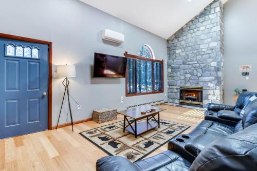 uma sala de estar com uma porta azul e uma lareira de pedra em White Haven Home with Hot Tub and Nearby Lake Access em White Haven