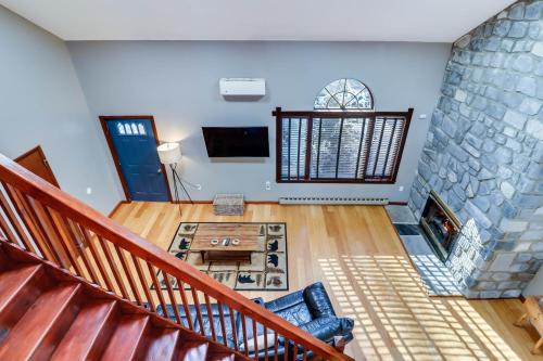 uma sala de estar com uma escada e uma parede de pedra em White Haven Home with Hot Tub and Nearby Lake Access em White Haven