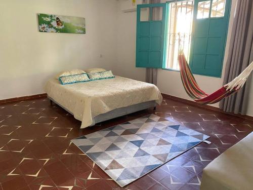 a bedroom with a bed and a hammock in a room at Casa campestre San José - Descansa y Diviértete in Santo Tomás