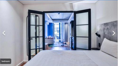 1 dormitorio con 1 cama y puerta abierta en Station House Ocean View Apartment, en Ciudad del Cabo
