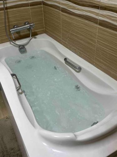 a bath tub filled with water in a bathroom at 3 bedrooms flat,fully equipped in Cairo