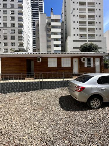 ein Auto, das vor einem Gebäude mit hohen Gebäuden parkt in der Unterkunft Loft Lux 4 in Chapecó