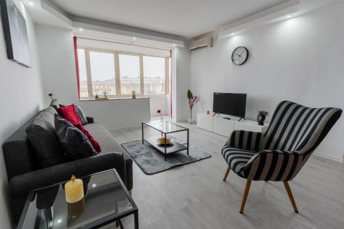 a living room with a couch and a chair and a tv at Quiet Apartment Ruby Horizon in Bucharest