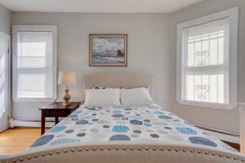 a bedroom with a bed and two windows at NEW! Boston Entire House Near MBTA, 3 Mi to Fenway! in Boston