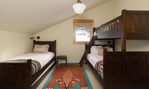 a bedroom with two bunk beds and a ladder at Black Eagle 24 in Big Sky