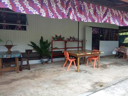 um quarto com uma mesa e cadeiras e uma bandeira em Ravehei smile relais 3 Huahine em Haapu