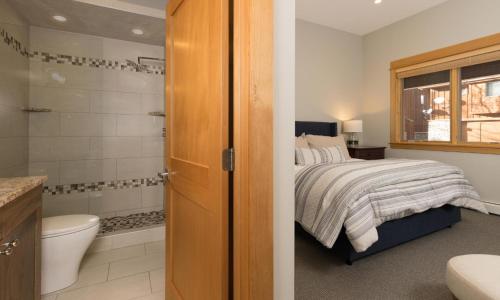 a bedroom with a bed and a bathroom with a shower at Black Eagle 24 in Big Sky