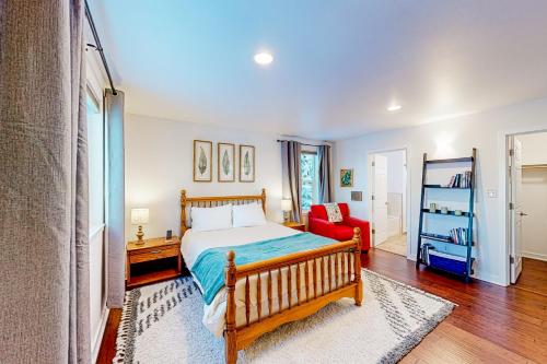 a bedroom with a bed and a red chair at Bear Valley Mountain Retreat in Anchorage