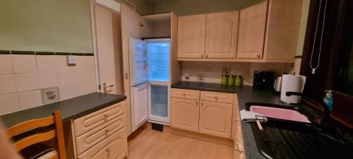 cocina con armarios de madera y encimera en 2 Bed Apt, Westend, recently redecorated, 2 king beds, Close to Ninewells, Fully Equipped, Families, Contractors and Trades, Mid Stays Welcome, en Dundee
