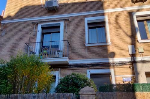 a brown brick house with a fence in front of it at Apartamento Turístico Zaragoza in Zaragoza