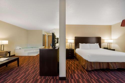 a large hotel room with a bed and a tub at Best Western Hermiston Inn in Hermiston