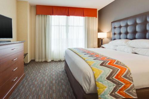 a hotel room with a bed and a flat screen tv at Drury Inn & Suites Fort Myers Airport FGCU in Fort Myers