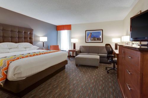 ein Hotelzimmer mit einem Bett und einem Flachbildfernseher in der Unterkunft Drury Inn & Suites Columbia Stadium Boulevard in Columbia