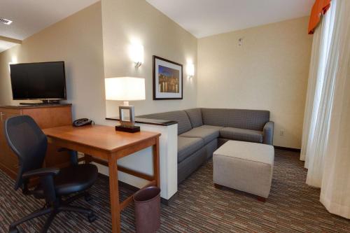 a living room with a couch and a table in a hotel room at Drury Inn & Suites Fort Myers Airport FGCU in Fort Myers