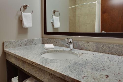 a bathroom counter with a sink and a mirror at Drury Inn & Suites Pittsburgh Airport Settlers Ridge in Pittsburgh