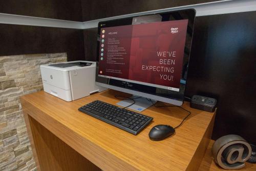 a computer monitor and a keyboard and mouse on a desk at Drury Inn & Suites Pittsburgh Airport Settlers Ridge in Pittsburgh