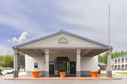 a building with orange pots in front of it at Motel 6 Nacogdoches, TX in Nacogdoches