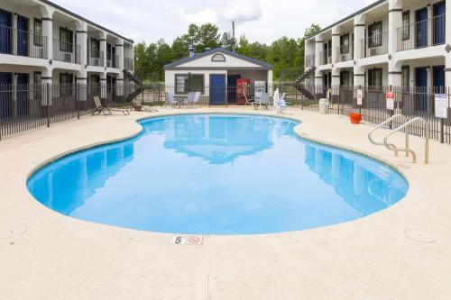 een zwembad in een hotel met blauw water bij Motel 6 Nacogdoches, TX in Nacogdoches