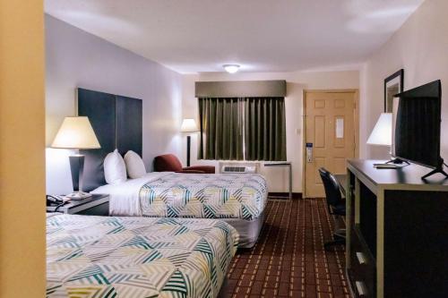 een hotelkamer met 2 bedden en een flatscreen-tv bij Motel 6 Nacogdoches, TX in Nacogdoches