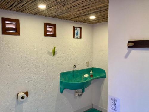 een badkamer met een groene wastafel aan een muur bij Posada Paloma in San Agustinillo