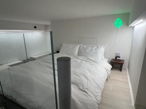 um quarto com uma cama branca e um papagaio verde por cima. em 0M Plant Turin em Turim