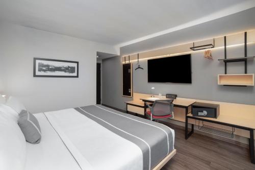 a bedroom with a bed and a desk and a tv at City Express Plus by Marriott Ciudad de México Insurgentes Sur in Mexico City
