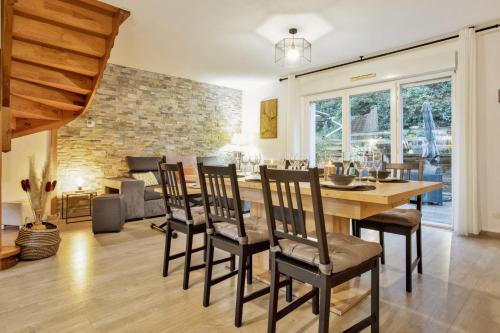 une salle à manger avec une table et des chaises en bois dans l'établissement La Maison des Embruns - Welkeys, à Capbreton