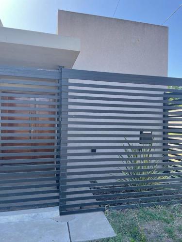a fence next to a building with a plant at La Casa de White in Colón Buenos Aires Province