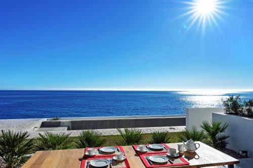 a table on a balcony with a view of the ocean at CasaCarbonito in Carboneras