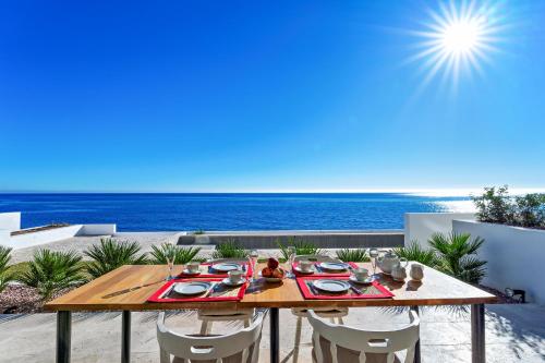 a table and chairs on a patio with the ocean at CasaCarbonito in Carboneras