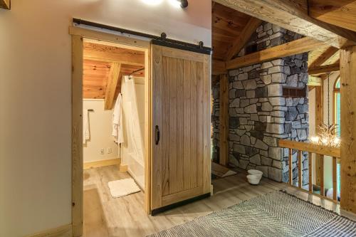 Habitación con puerta y pared de piedra. en Beautiful chalet on 5 acres - 2 min to Village! Hot-Tub, Sauna, Fire Pit!, en Ellicottville