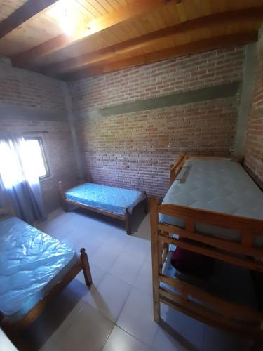 una camera con due letti e un muro di mattoni di La casona del Paso a Paso de la Patria