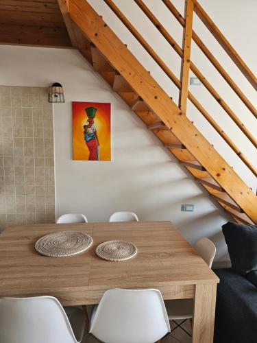 a dining room with a wooden table with chairs at Soleil Beach House in Santa Maria