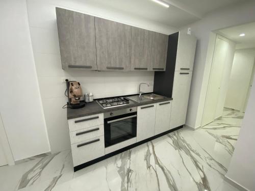una cucina con armadietti bianchi e piano cottura di White House a Napoli