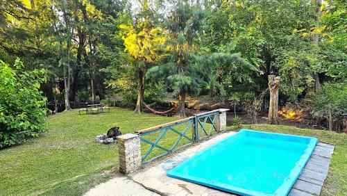 uma piscina num quintal ao lado de um parque em Casa con PILETA al borde del RIO em Benavídez