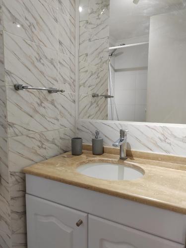 a bathroom with a sink and a mirror at Lindo departamento a pasos de la playa in Coquimbo