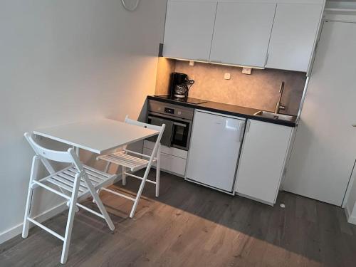 una pequeña cocina con mesa, mesa y sillas en Lägenhet med egen ingång., en Sundsvall