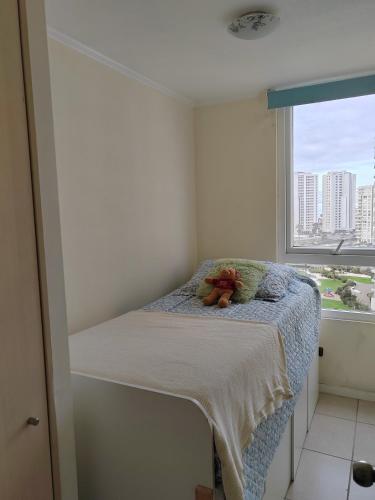 un pequeño dormitorio con un osito de peluche sentado en una cama en Lindo departamento a pasos de la playa, en Coquimbo