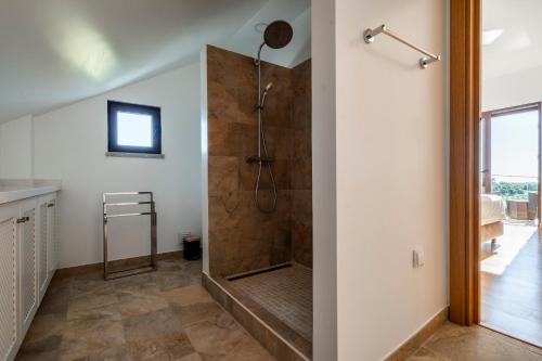 un bagno con doccia con porta in vetro di Casa da Alvorada a Tavira