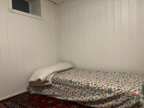 un pequeño dormitorio con una cama con una manta. en Råstadveien 20, 3228. Sandefjord, en Sandefjord