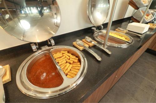 a buffet with a plate of sauce and french fries at City Express by Marriott Monterrey Universidad in Monterrey