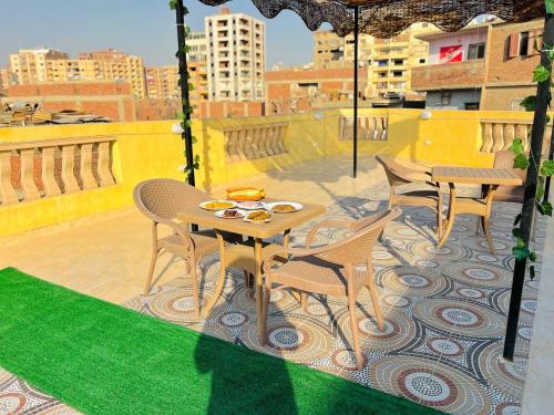 um pátio com uma mesa e cadeiras numa varanda em Four pyramids Guest house pyramids View em Cairo
